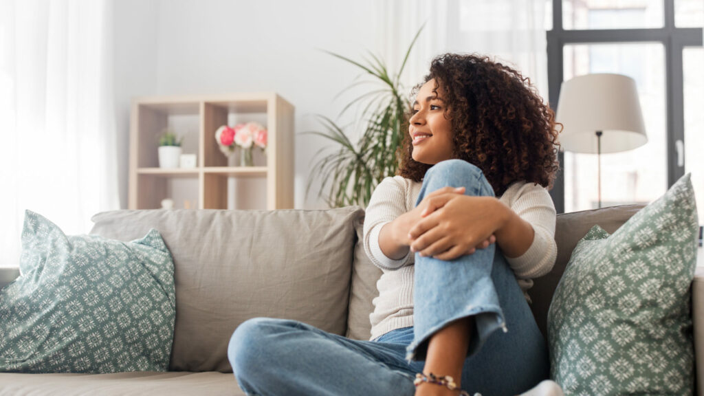 Woman at home sitting on sofa